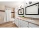 Bathroom featuring a double vanity with granite countertop, framed mirrors, modern lighting, and tiled shower at 2406 S Mulberry --, Mesa, AZ 85202