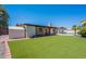 Expansive backyard with green lawn, covered patio, storage shed, and a swimming pool at 2446 E Hale St, Mesa, AZ 85213