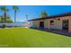 View of the lush backyard with artifical grass and palm trees at 2446 E Hale St, Mesa, AZ 85213