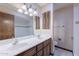Bathroom with double sink vanity, decorative light fixture, and tiled shower at 2446 E Hale St, Mesa, AZ 85213