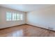 Bright, minimalist bedroom with hardwood floors, large window, and crisp white walls at 2446 E Hale St, Mesa, AZ 85213