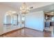 Elegant dining area with hardwood floors, a chandelier, and views to the kitchen and arched doorway at 2446 E Hale St, Mesa, AZ 85213