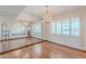Bright dining room with a chandelier, hardwood floors, and large windows that offers views to living area at 2446 E Hale St, Mesa, AZ 85213