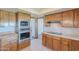The kitchen showcases wooden cabinetry and stainless steel oven and microwave at 2446 E Hale St, Mesa, AZ 85213