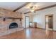 Cozy living room with brick fireplace, wooden beams, and light wood flooring at 2446 E Hale St, Mesa, AZ 85213