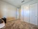 Carpeted bedroom with closet doors and neutral-colored walls at 24552 W Hilton Ave, Buckeye, AZ 85326