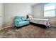 Cozy bedroom featuring a turquoise loveseat with a window for natural light at 24552 W Hilton Ave, Buckeye, AZ 85326