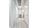 Bright hallway with tile flooring, white walls, and access to multiple rooms at 24552 W Hilton Ave, Buckeye, AZ 85326