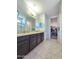 Main bathroom with double sinks, granite countertops, a walk-in closet, and a glass shower at 24552 W Hilton Ave, Buckeye, AZ 85326