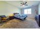 Cozy main bedroom with neutral carpet, ceiling fan, and large window providing ample natural light at 24552 W Hilton Ave, Buckeye, AZ 85326