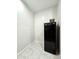Compact pantry space with a black refrigerator and tile flooring at 24552 W Hilton Ave, Buckeye, AZ 85326