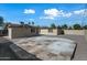 Gravel backyard featuring a large concrete patio and a partial view of the home's exterior under a bright blue sky at 2601 N 51St St, Phoenix, AZ 85008