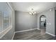 A home dining space with gray flooring, featuring a modern chandelier and an archway view of the kitchen at 2601 N 51St St, Phoenix, AZ 85008