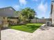 A beautifully landscaped backyard with green lawn, stone patio, barbecue area, and mature palm trees at 2822 E Constance Way, Phoenix, AZ 85042