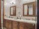 Luxurious bathroom with double vanities, framed mirrors, granite countertops, and marble walls at 2822 E Constance Way, Phoenix, AZ 85042