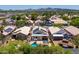 Aerial view showcases homes with pools, solar panels, and desert landscaping in a neighborhood at 316 W Kelton Ln, Phoenix, AZ 85023