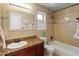 Bathroom featuring a tub with shower, warm tile, granite counters, and a framed mirror at 316 W Kelton Ln, Phoenix, AZ 85023