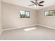 A bright bedroom with carpet, ceiling fan, and two windows allowing natural light at 3209 N 20Th Pl, Phoenix, AZ 85016