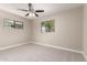 A bright bedroom with carpet, ceiling fan, and two windows allowing natural light at 3209 N 20Th Pl, Phoenix, AZ 85016