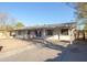Single story house with a carport, painted white with gray trim and a gravel yard at 3418 W Roma Ave, Phoenix, AZ 85017