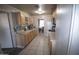 Kitchen featuring wood cabinets, white appliances, tile floors, and a view into the dining area at 3418 W Roma Ave, Phoenix, AZ 85017