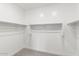 Walk-in closet features neutral carpet and white walls, shelf and rod system for ample storage at 3556 E Austin Dr, Gilbert, AZ 85296