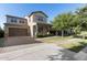 Charming two-story home with a brick driveway, well-maintained lawn, mature tree, and covered porch at 3556 E Austin Dr, Gilbert, AZ 85296