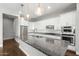 Gourmet kitchen boasts granite counters, stainless appliances, sleek cabinetry, and modern pendant lights at 3556 E Austin Dr, Gilbert, AZ 85296