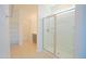 Bright bathroom with a glass-enclosed shower, tiled floors, and shelving for storage at 3611 E Archer Dr, San Tan Valley, AZ 85140