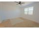 Bright, carpeted bedroom with a ceiling fan and a large window providing natural light at 3611 E Archer Dr, San Tan Valley, AZ 85140