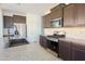 Bright kitchen featuring an island with sink, stainless steel appliances and dark wood cabinetry at 3611 E Archer Dr, San Tan Valley, AZ 85140
