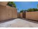 Empty back patio enclosed by a brick wall, featuring a storage closet and metal gate at 4268 N 68Th Ave, Phoenix, AZ 85033