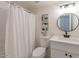 Clean bathroom with white vanity, round mirror and a shower with a curtain at 4268 N 68Th Ave, Phoenix, AZ 85033