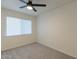 Bedroom features neutral carpet, a ceiling fan and window with bright natural light at 4268 N 68Th Ave, Phoenix, AZ 85033