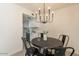 Cozy dining area with modern light fixture, views into the bright white kitchen at 4268 N 68Th Ave, Phoenix, AZ 85033
