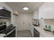 Modern kitchen with white cabinets, quartz countertops, stainless steel appliances, and stylish finishes at 4268 N 68Th Ave, Phoenix, AZ 85033