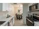 Well-lit kitchen with stainless steel appliances, white cabinets and an adjacent dining area at 4268 N 68Th Ave, Phoenix, AZ 85033