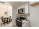 Modern kitchen with white cabinets, quartz countertops, stainless steel appliances, and an adjacent dining area at 4268 N 68Th Ave, Phoenix, AZ 85033