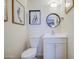 Cozy bathroom featuring a toilet, mirror, vanity and decorative fashion sketches on the wall at 5335 N 78Th St, Scottsdale, AZ 85250