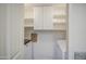 Bright laundry room with a washing machine, dryer, cabinets, and open shelves at 5335 N 78Th St, Scottsdale, AZ 85250