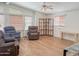 Bright living room featuring laminate floors, three recliners, wood bookcase, and ample natural light at 5735 E Mcdowell Rd # 436, Mesa, AZ 85215