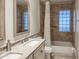 Bright bathroom with double vanity, tub and shower featuring travertine-look tile at 6639 E Pershing Ave, Scottsdale, AZ 85254