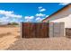 Wooden backyard gate framed with gravel and block wall at 8226 W Swansea Dr, Arizona City, AZ 85123