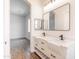 Bathroom featuring double sinks, sleek fixtures, subway tile, and a view to the bedroom at 8226 W Swansea Dr, Arizona City, AZ 85123