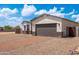 Single-story home showcasing a modern two-car garage and brick driveway, blending style and convenience at 8226 W Swansea Dr, Arizona City, AZ 85123