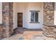 Inviting home entrance featuring a rich wood door, stone accents, and an elegant brick walkway at 8226 W Swansea Dr, Arizona City, AZ 85123