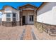 Charming home entrance featuring a decorative stone facade, stylish front door, and landscaped walkway at 8226 W Swansea Dr, Arizona City, AZ 85123