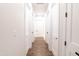 Hallway with white doors, wood-look tile floor and neutral colored walls at 8226 W Swansea Dr, Arizona City, AZ 85123
