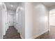 Well-lit hallway with crisp white walls and wood-look tile flooring at 8226 W Swansea Dr, Arizona City, AZ 85123