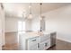 Bright kitchen with an island, stainless steel appliances, pendant lights, and a view of the living space at 8226 W Swansea Dr, Arizona City, AZ 85123